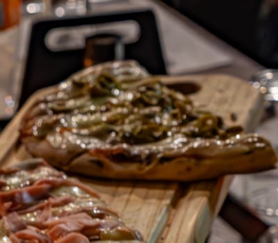 Pizza con tiras de morrón gratinadas sobre tabla de madera